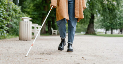 Nainen kävelee sokean kepin kanssa.