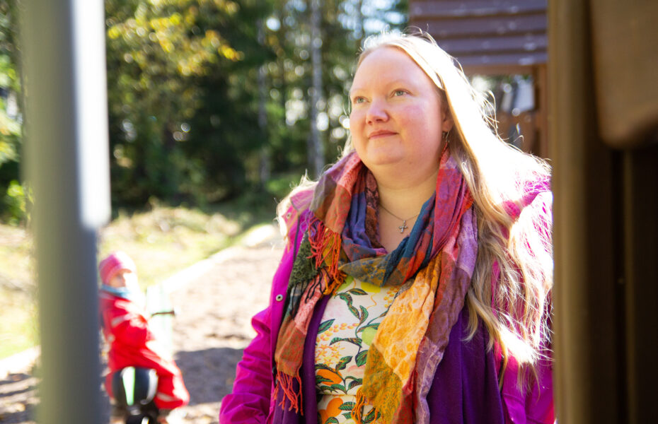 Nainen katsoo eteenpäin. Hänen hiuksilleen loistaa aurinko kirkkaasti.