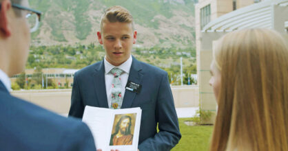 Mormonilähetystyöntekijä pitää Jeesuksen kuvaa kädessään.