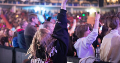 Tyttö osoittaa sormella korkealle ilmaan.