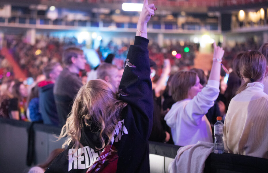 Tyttö osoittaa sormella korkealle ilmaan.