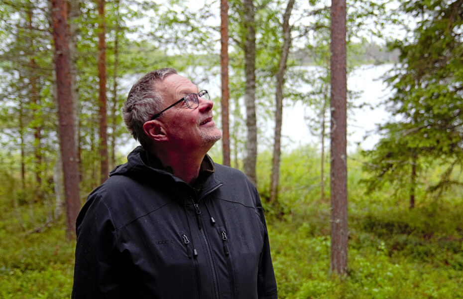 Timo vihreässä metsässä, katselee yläviistoon.