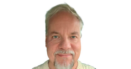 Mies, jolla on harmaantuneet hiukset ja parta.