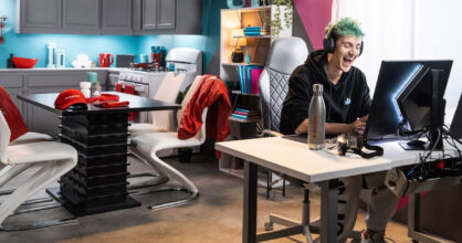 Mies istuu koneen äärellä. Hänellä on kuulokkeet. Taustalla näkyy hänen asuntonsa sisustusta ja huonekaluja.