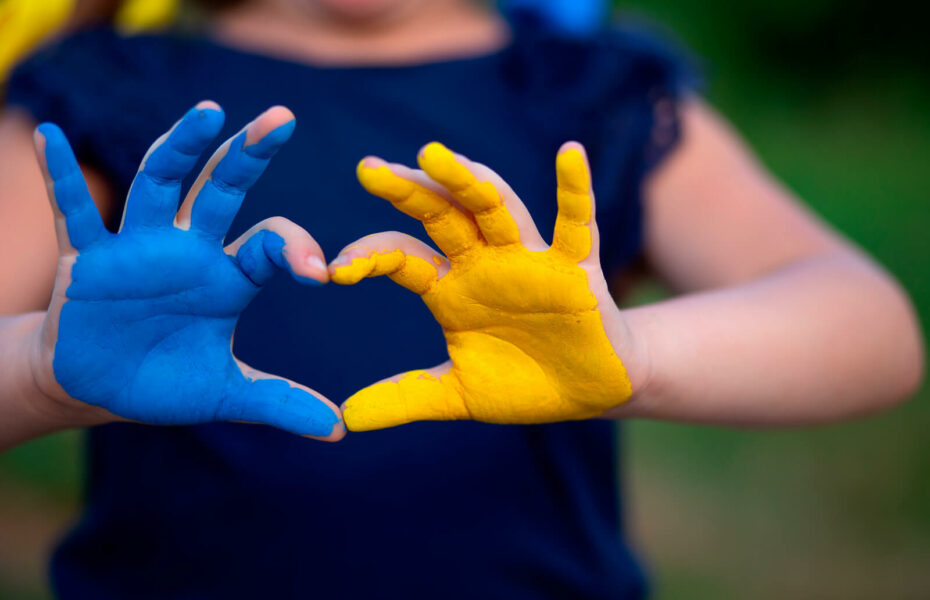 Ukrainan lipun värein maalatut kädet tekevät sydämen.