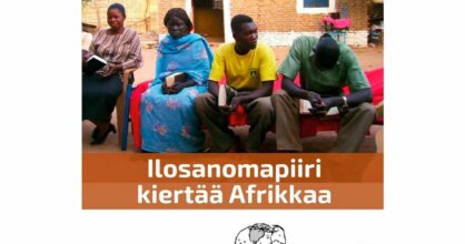 Afrikkalaisia istuu Raamattu kädessä.