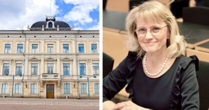 Nainen istuu hymyillen oikeussalissa.