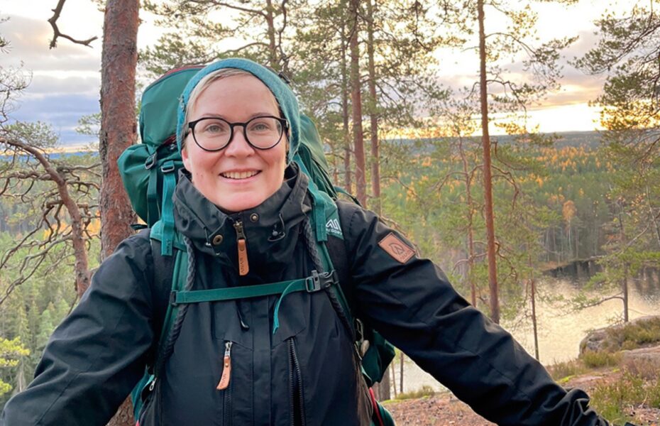 Nainen korkealla kallion rinteellä.